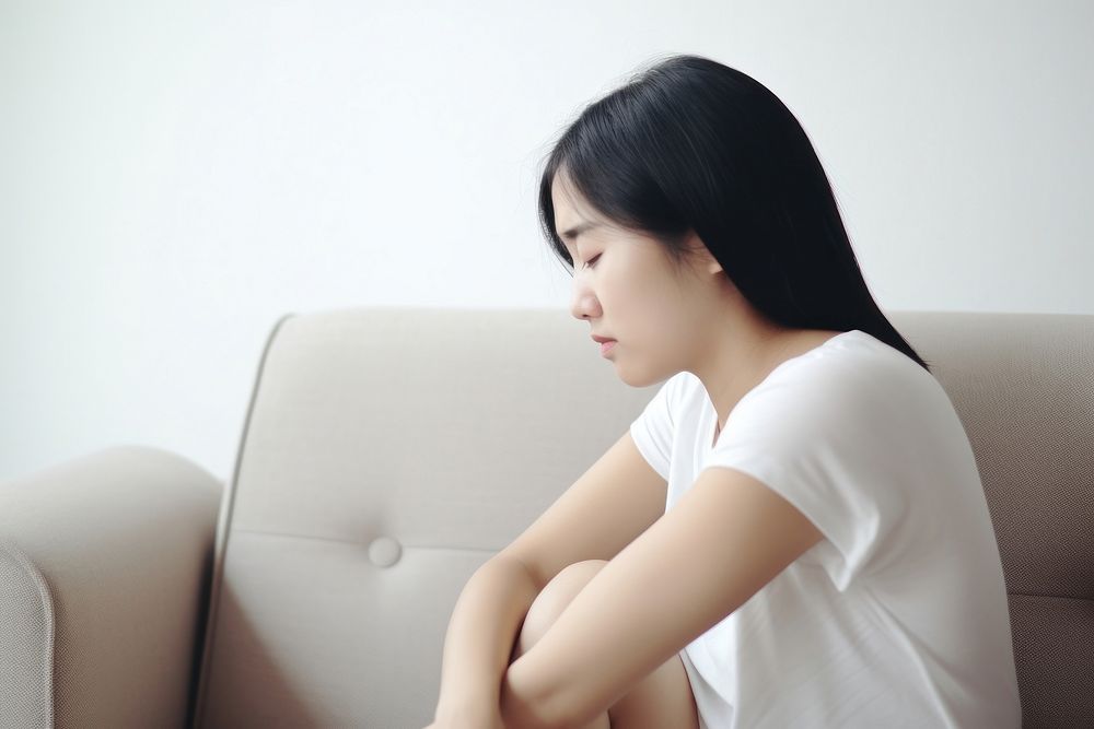 An east asian woman suffering from sickness worried sitting adult.