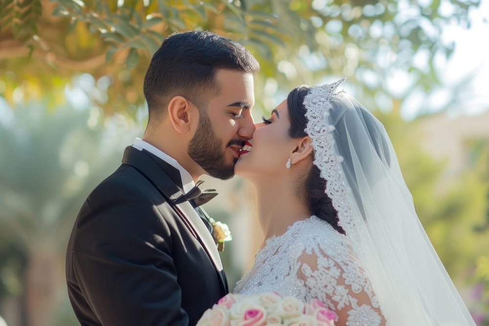 Middle eastern couple kissing in their wedding day fashion smiling dress.