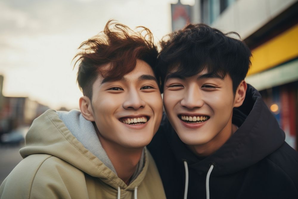 Korean gay couple smile outdoors love togetherness.