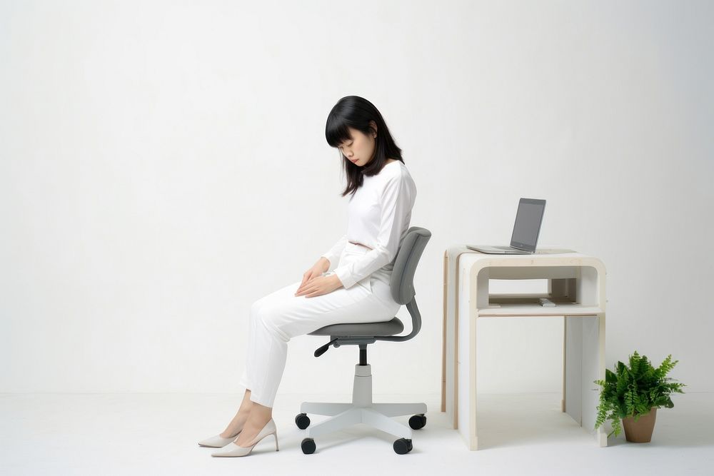 An east asian woman suffering from stressness sitting furniture computer.
