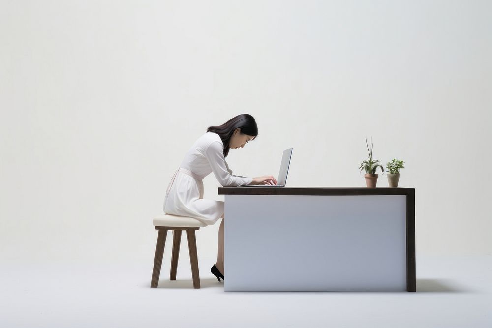 An east asian woman suffering from stressness sitting desk furniture.