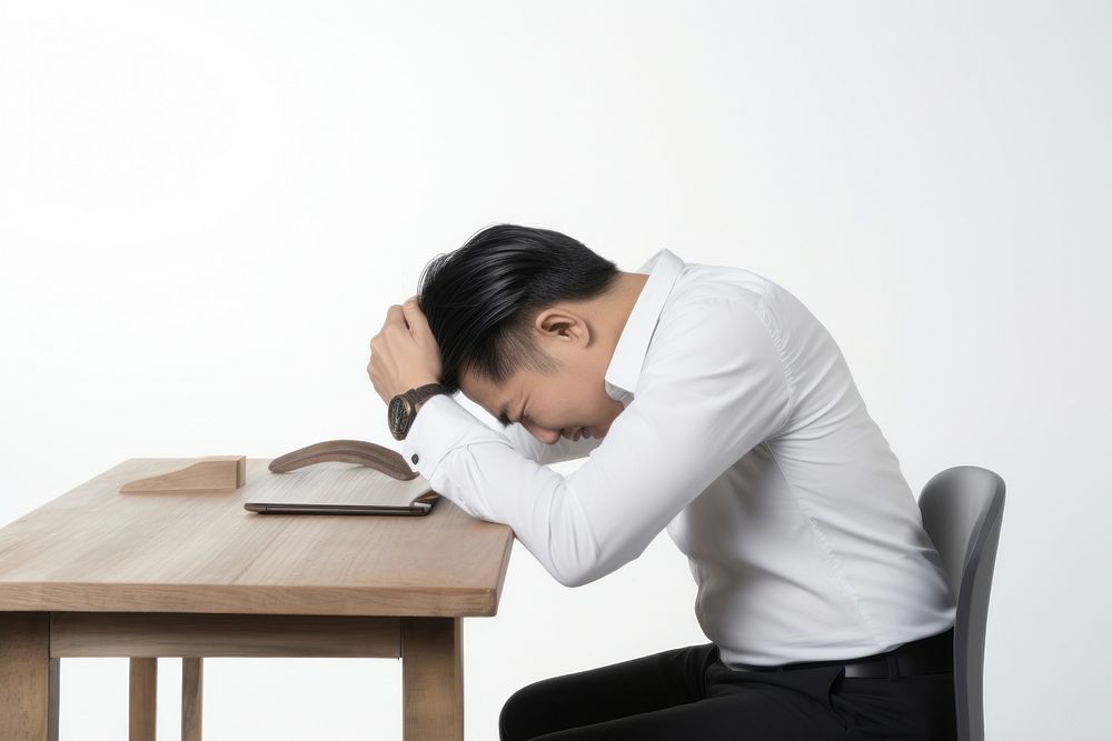 An east asian man suffering from headache worried sitting adult.