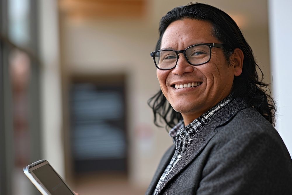 Native american business man smiling whild holding a tablet glasses office adult. AI generated Image by rawpixel.