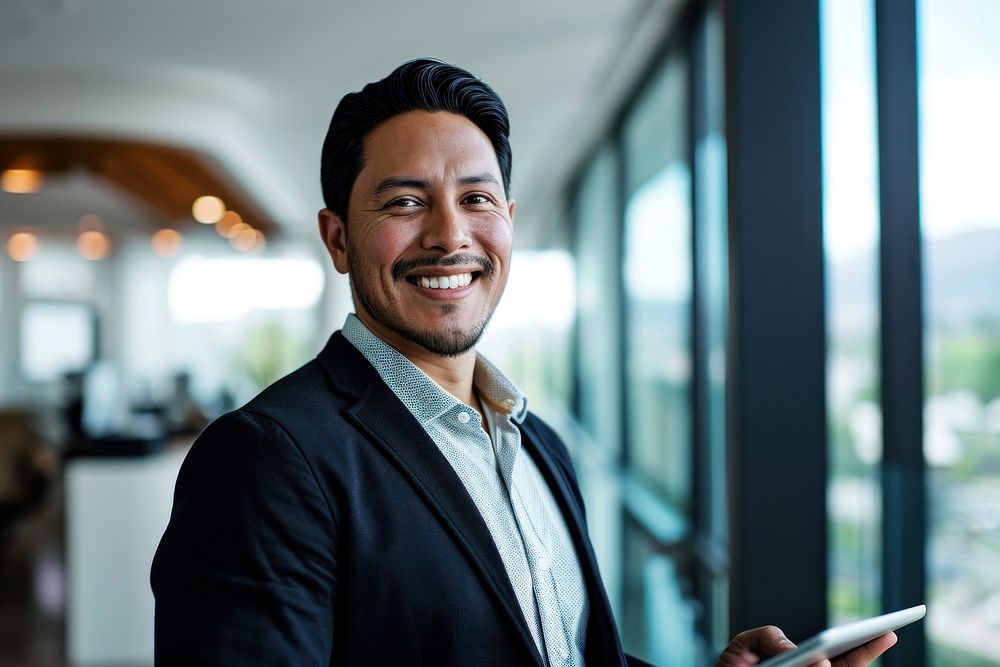 Native american business man smiling whild holding a tablet office adult smile. AI generated Image by rawpixel.