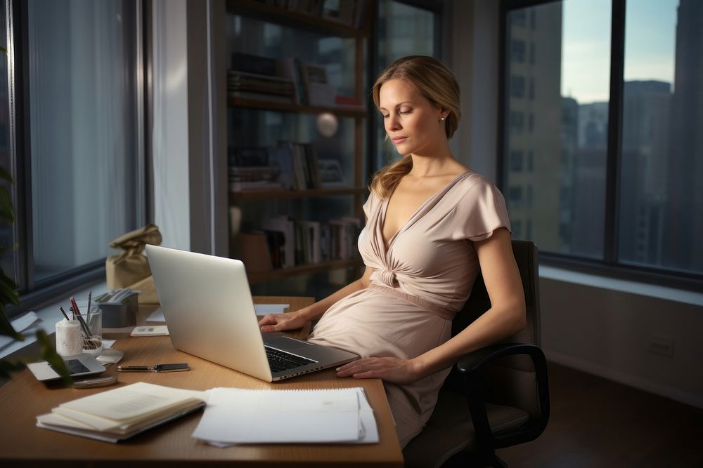 Pregnant mother working sitting laptop furniture.