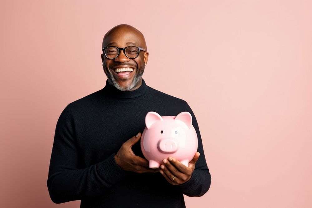 Black man holding piggy bank investment retirement happiness.