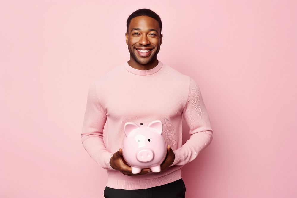Black man holding piggy bank representation investment happiness.