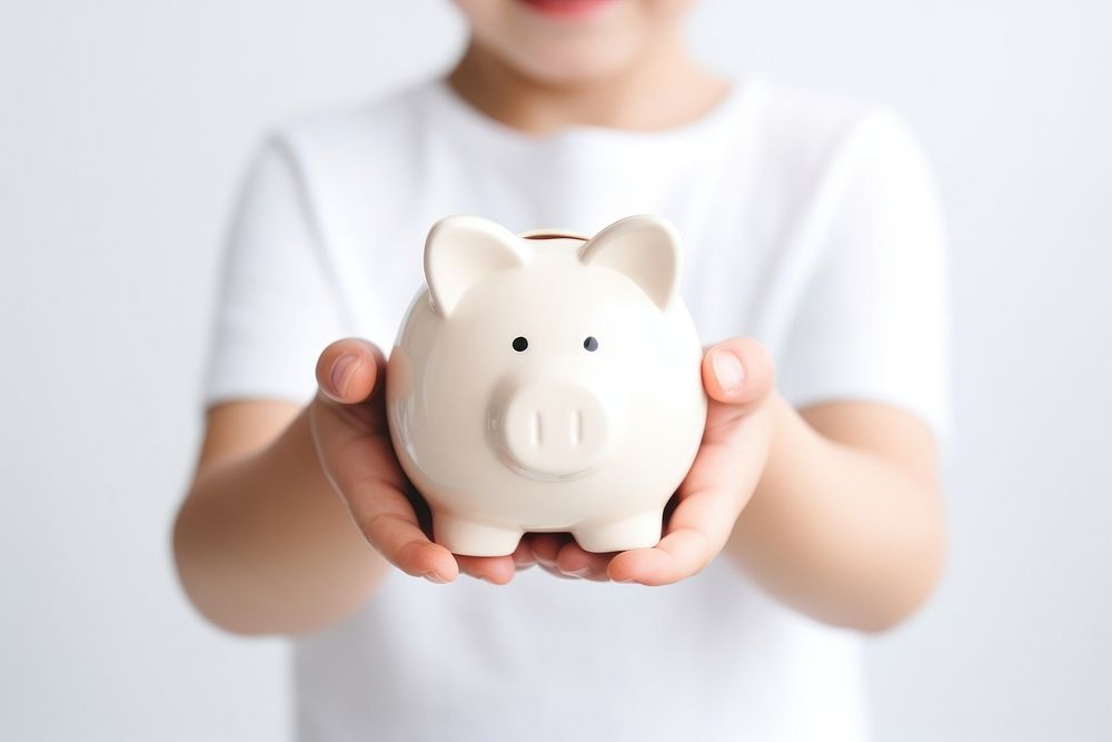 Kid holding piggy bank representation investment currency.