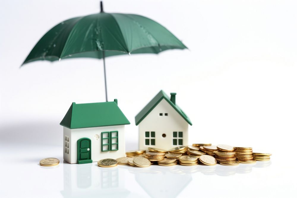 Coins and a house in white color under a green umbrella architecture investment shielding.