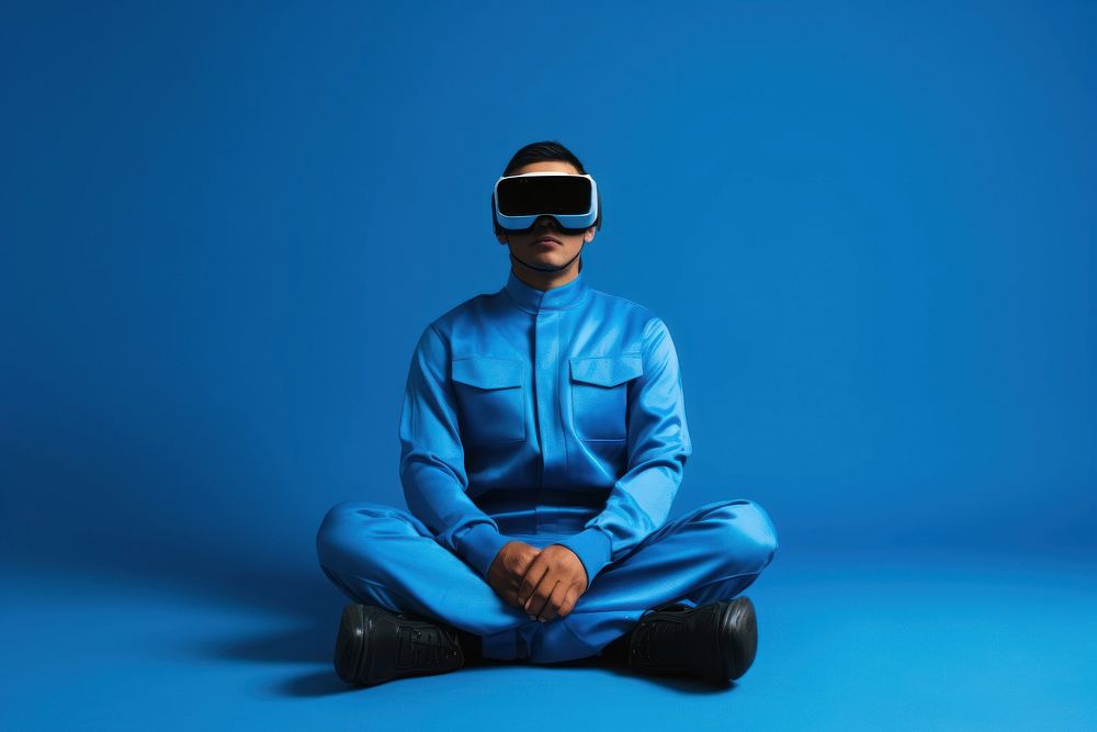 Person wearing a virtual reality headset and sitting adult blue protection.