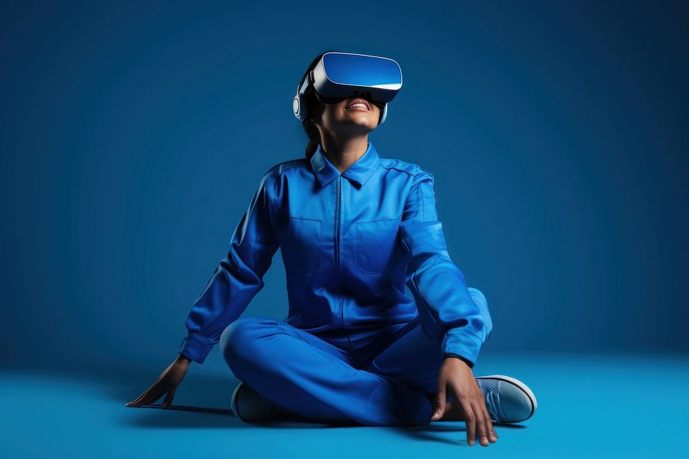 Woman wearing a virtual reality headset and sitting portrait photo blue.