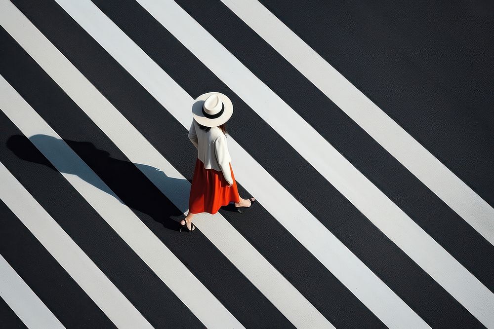 A minimalistic photography of a lady crossing the road advertisment style pedestrian outdoors clothing.