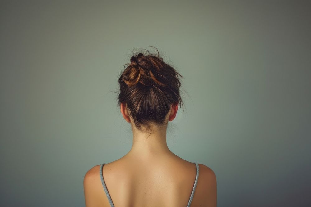 Woman showing her back with skin adult hairstyle ponytail.