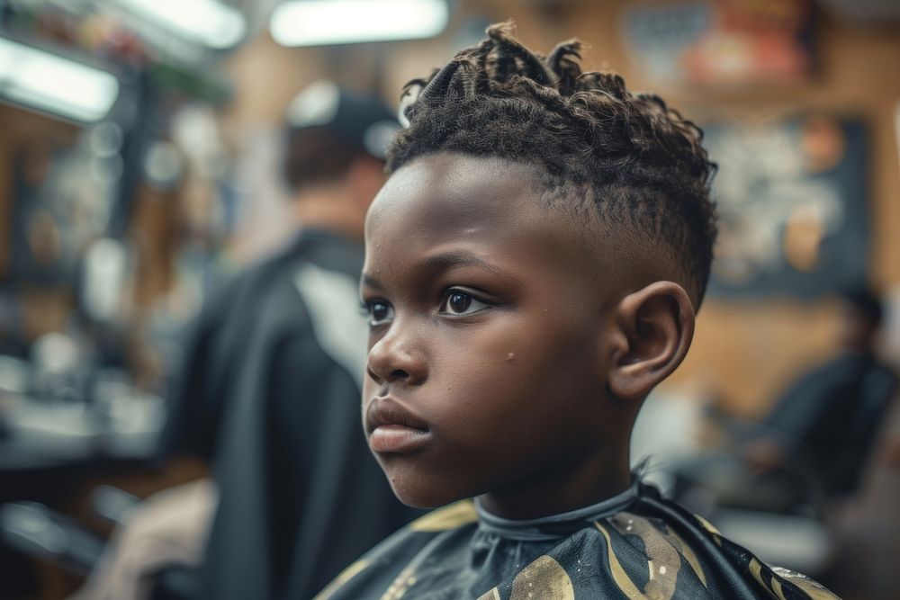 African American boy getting a haircut in barber hairdresser hairstyle portrait.