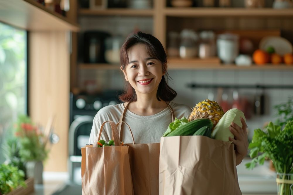 Middle age asian woman after shopping groceries at home adult plant food.