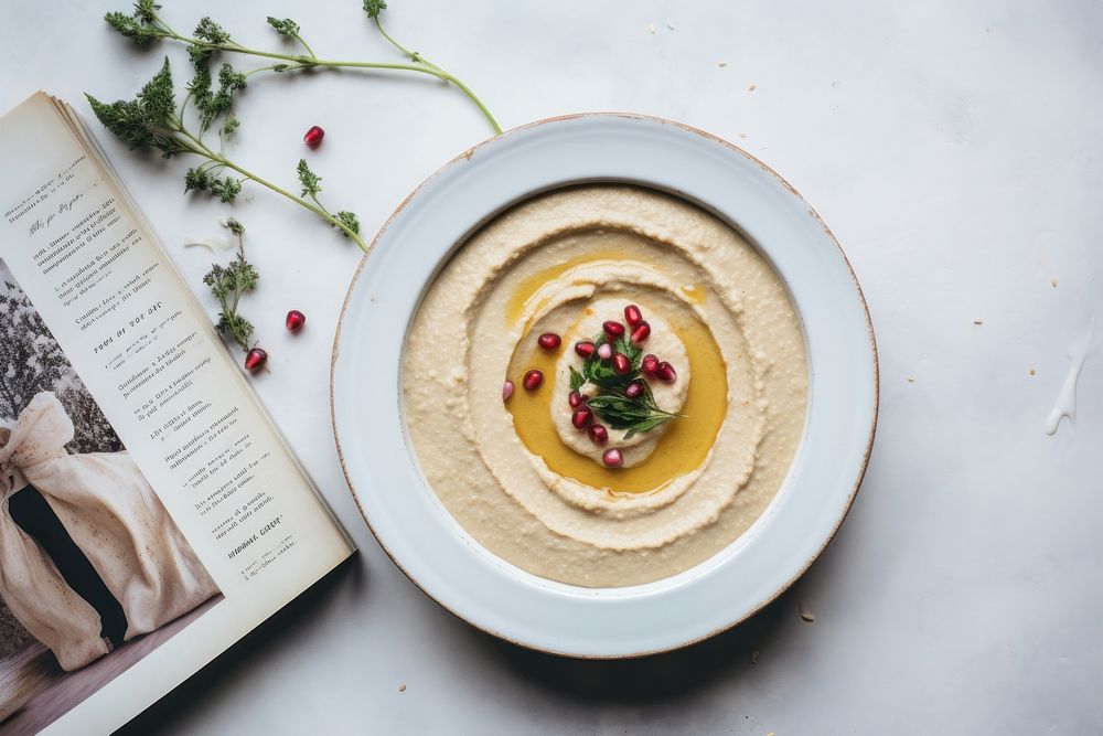 A White beige minimalistic photography of hummus in cook book style plate food meal.