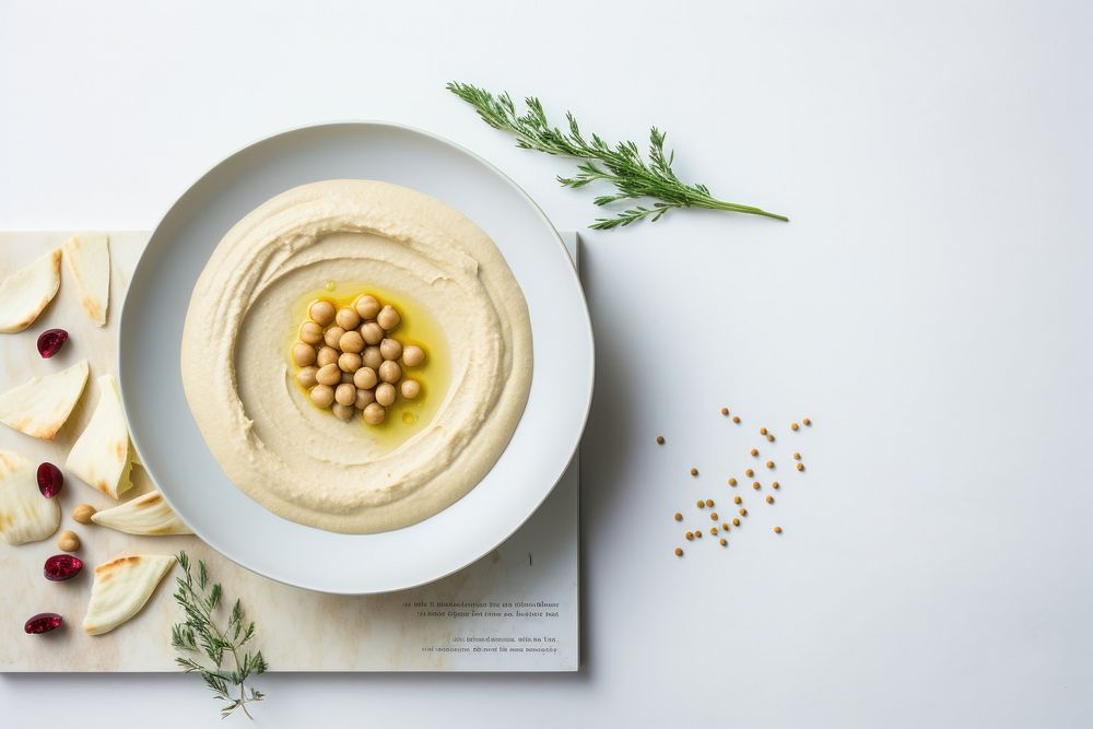 A White beige minimalistic photography of hummus in cook book style plate food meal.