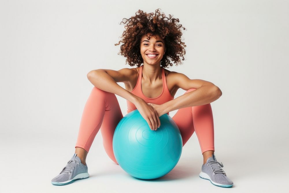 A smiling woman exercise sitting sphere.