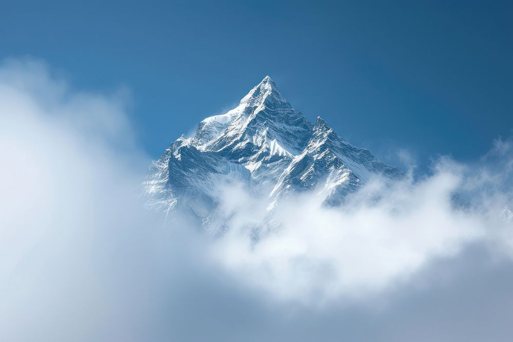 Photo of snowy mountain peek surrounded by cloud outdoors nature sky.