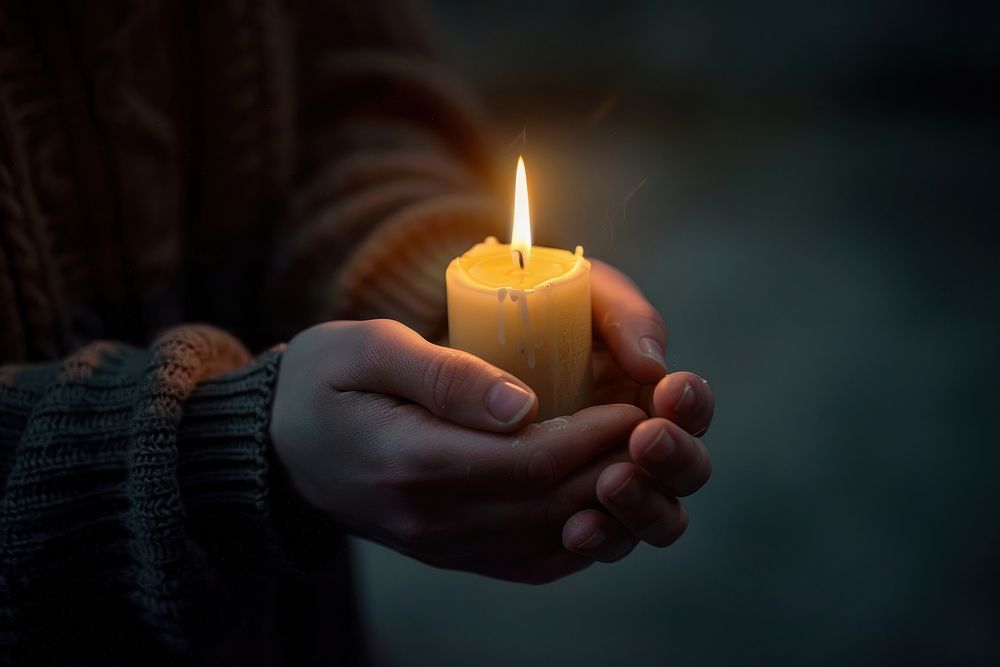 Hands holding candle burning spirituality.