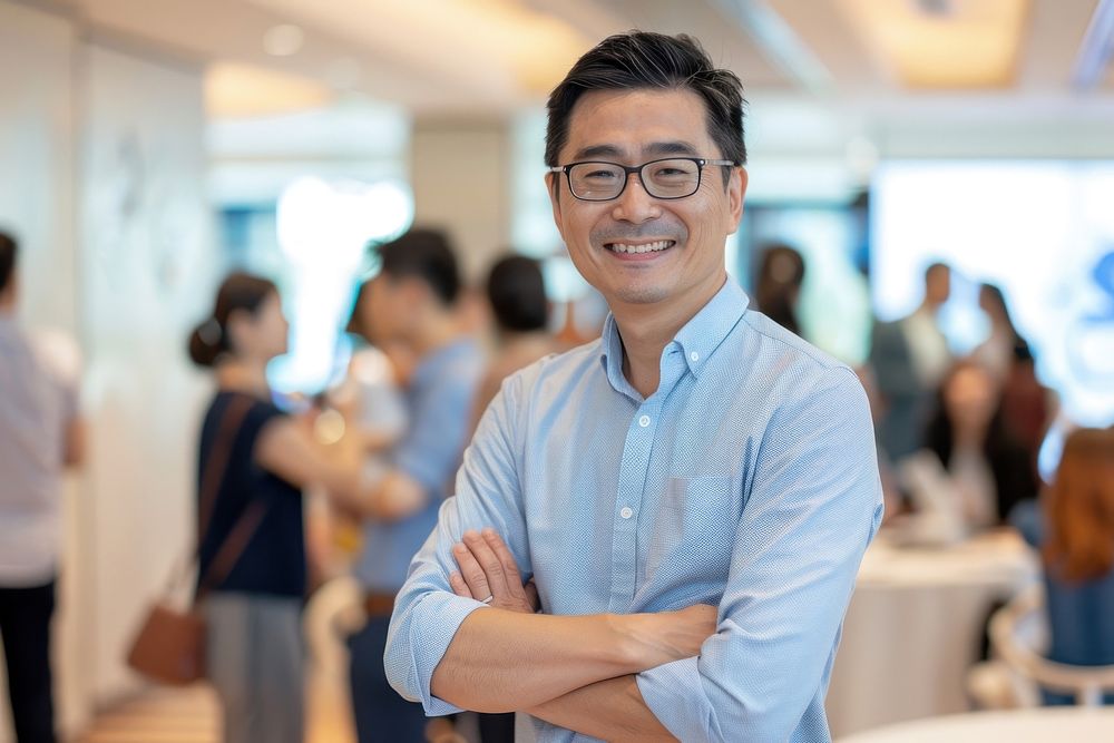 Asian man stand and smile against business people meeting in meeting room portrait glasses adult.