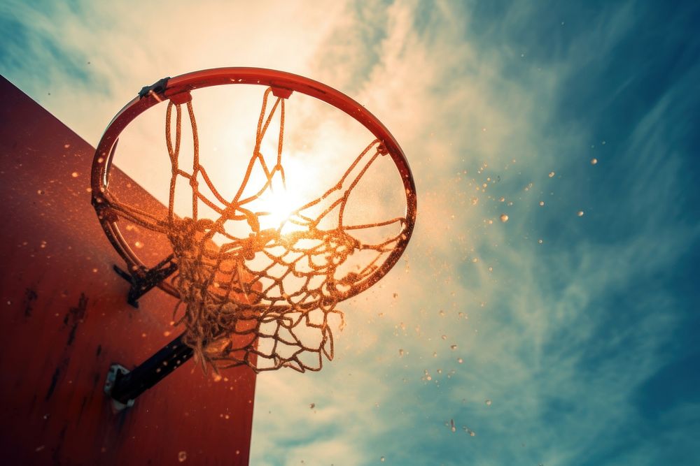 Basketball through basketball hoop sports chandelier sunlight.
