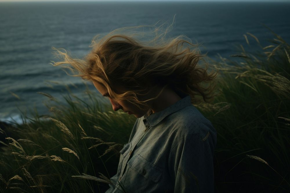 Lonely girl hands on head grass sea landscape.
