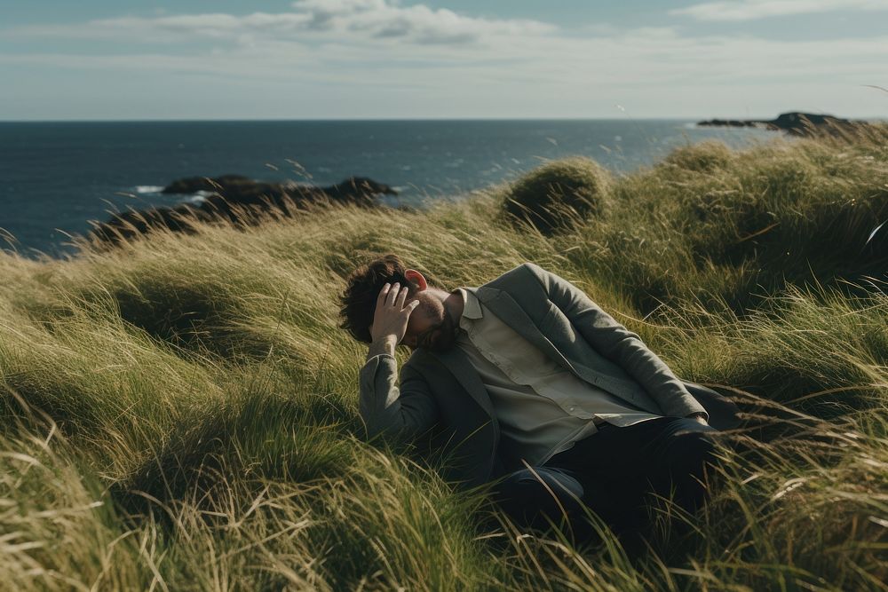 Lonely man hands on head grass sea outdoors.