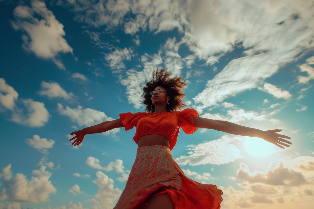 Black young woman dancing sky outdoors.