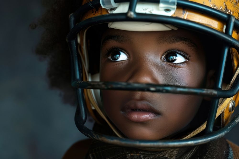 Black child football helmet portrait.