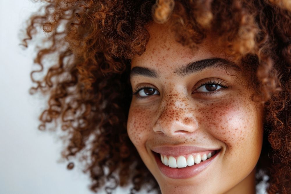 Woman with curly hair smiling adult smile skin.