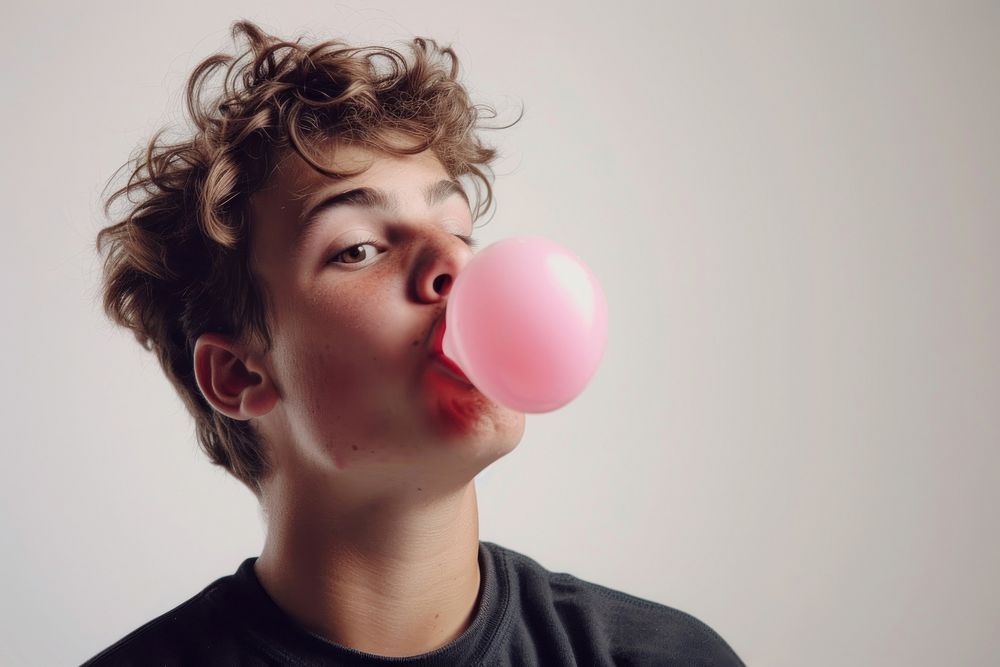 Young man blows off portrait balloon gum.