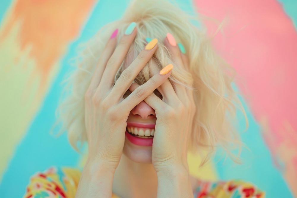 Woman covering her eyes laughing smiling blonde.