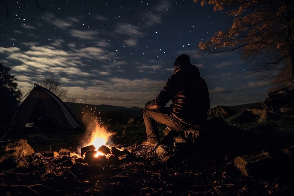 Young alone camping in autumn fire outdoors sitting.
