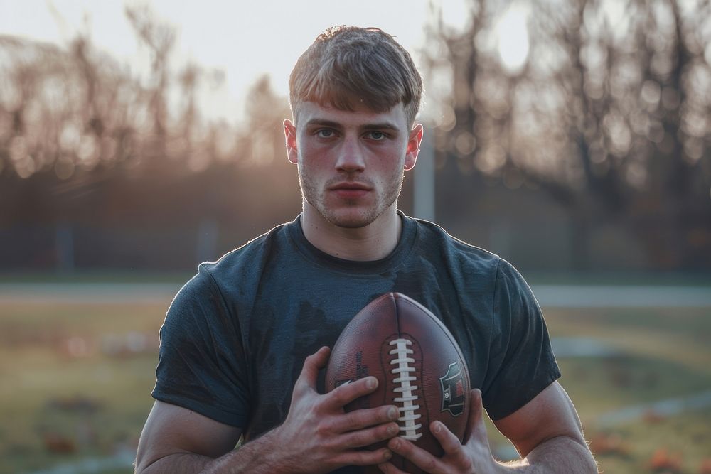 A football player man holding a football ball portrait sports photo.