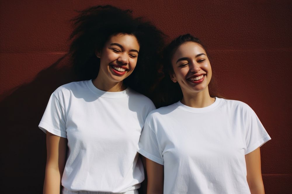 Two diverese women wearing white t-shirt smiling photography laughing portrait.