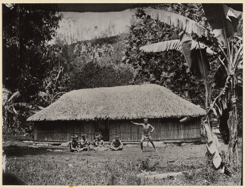 Man posed in front of hut