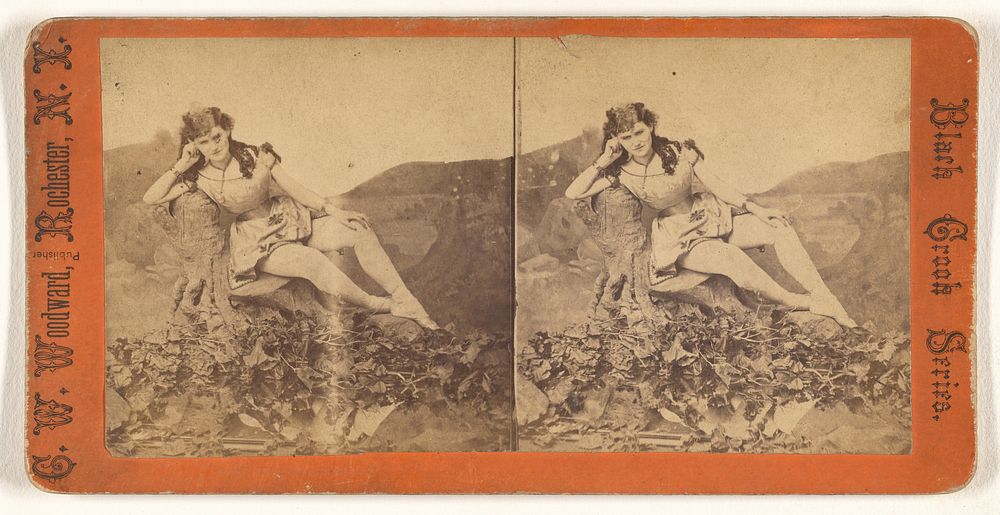 Woman posed on fake rock in studio by C W Woodward
