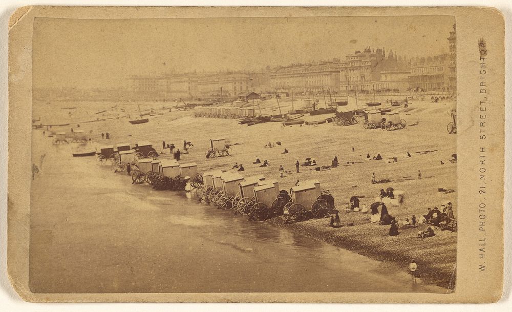 Beach scene showing bathing cabinets at shoreline, Brighton, England by W Hall