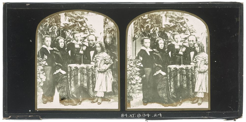 Unidentified family group: mother and father seated at a table, two boys and a girl standing with them