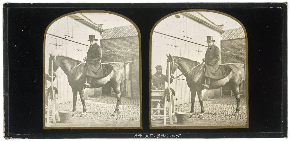 Unidentified British man wearing a top hat on horseback, another unidentified British man holding the bridle of the horse
