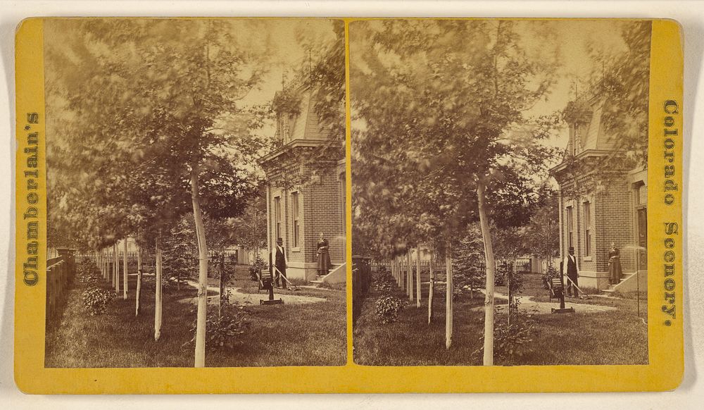 Man mowing lawn with hand mower, woman standing on steps, with house, garden and trees, somewhere in Colorado by W G…