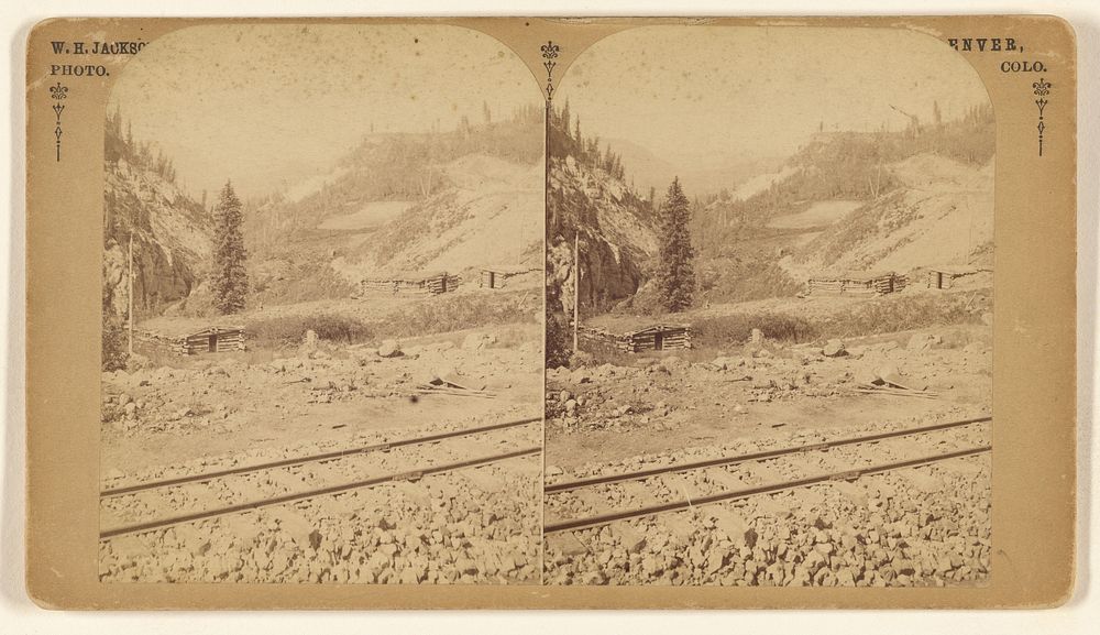Unidentfied canyon with railroad tracks, cabins in distance by William Henry Jackson