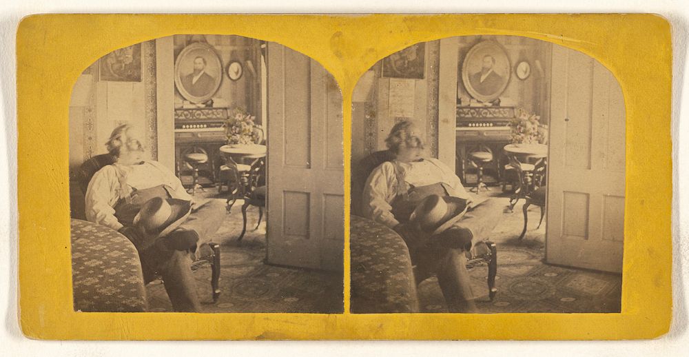 Samuel Clemens seated in a chair, hat on crossed legs