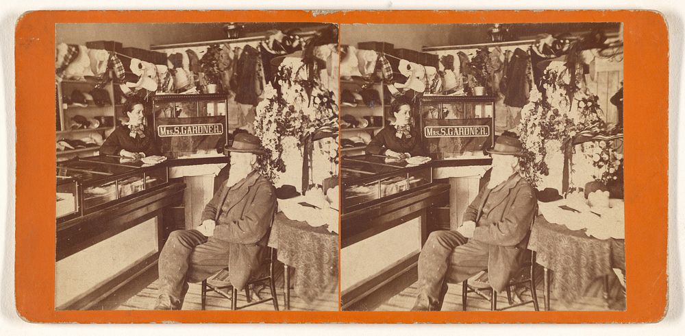 Interior of Mrs. S. Gardner's store, elder man with long white beard seated at front of counter with sign, woman behind…