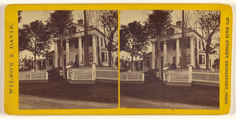 Long view of large house with columns, family on front porch by Wilson and Davis
