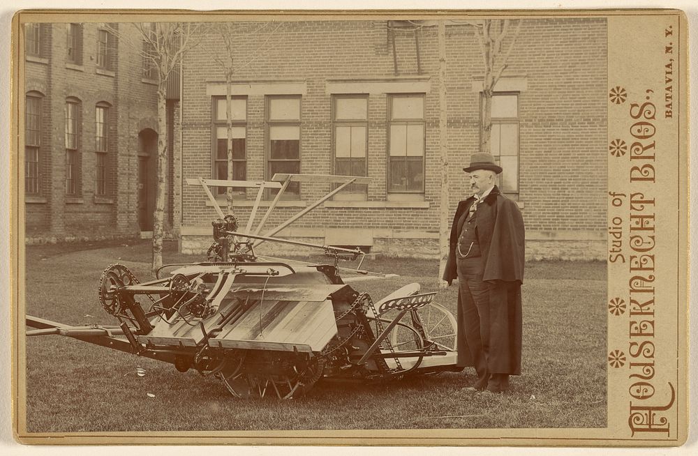 Man posing with a piece of farm machinery by Houseknecht and Brothers