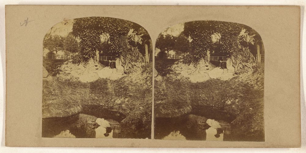 Woman seated on ground overlooking a brook, her reflection seen in the brook