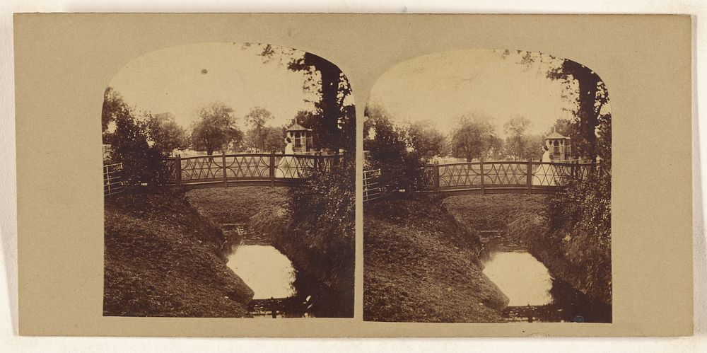 Woman crossing footbridge over stream