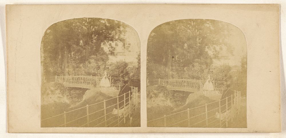 Two women crossing footbridge over stream